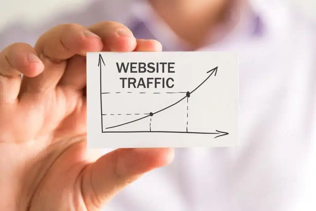  Person holding a card with a graph showing upward growth, labeled 'Website Traffic.'